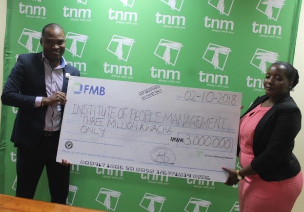 Butao (R) presenting cheque to Nyambo