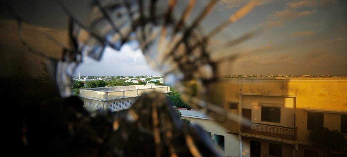 The skyline beyond the northern suburbs of Mogadishu is seen through a bullet hole in the window of a hotel in Somalia.