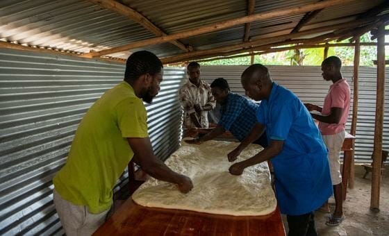 Kavugwa Shebulike Cadet (right) prepares dough with his employees and trainees at his bakery in Nyankanda refugee camp.